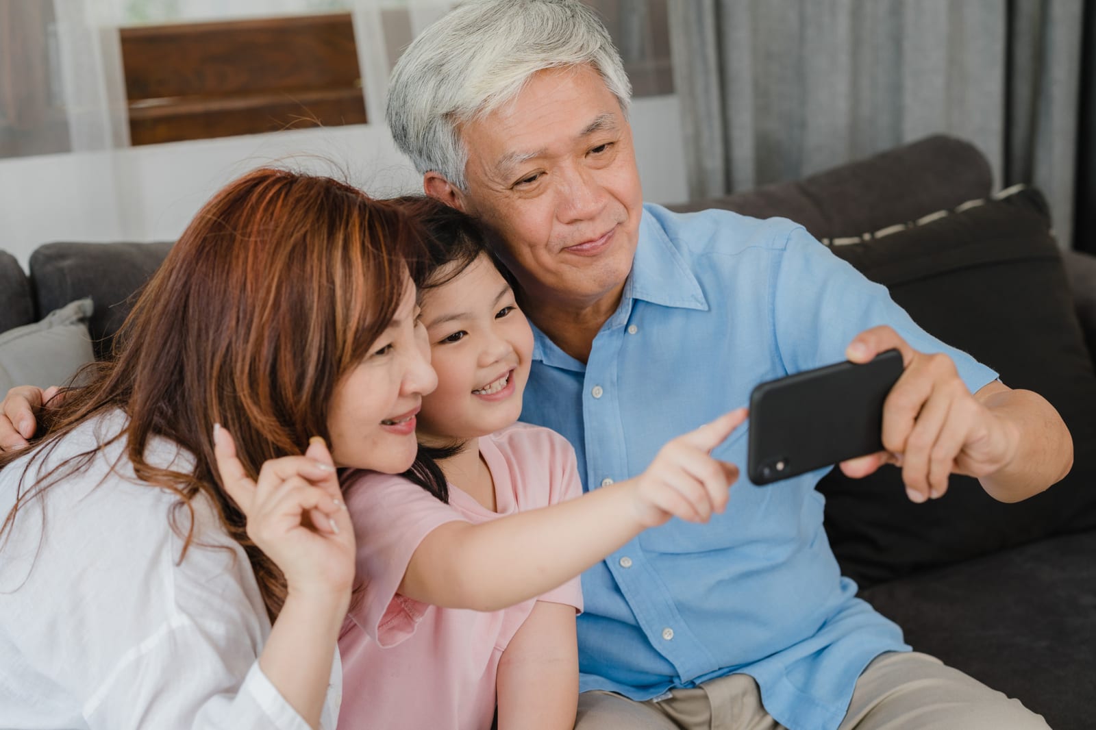孫と一緒に自撮りをする祖父母